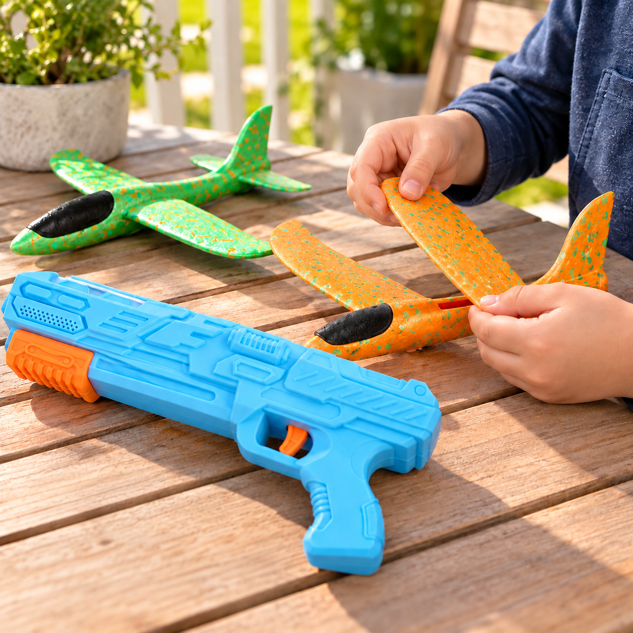 Child assembling a foam airplane on an outdoor table